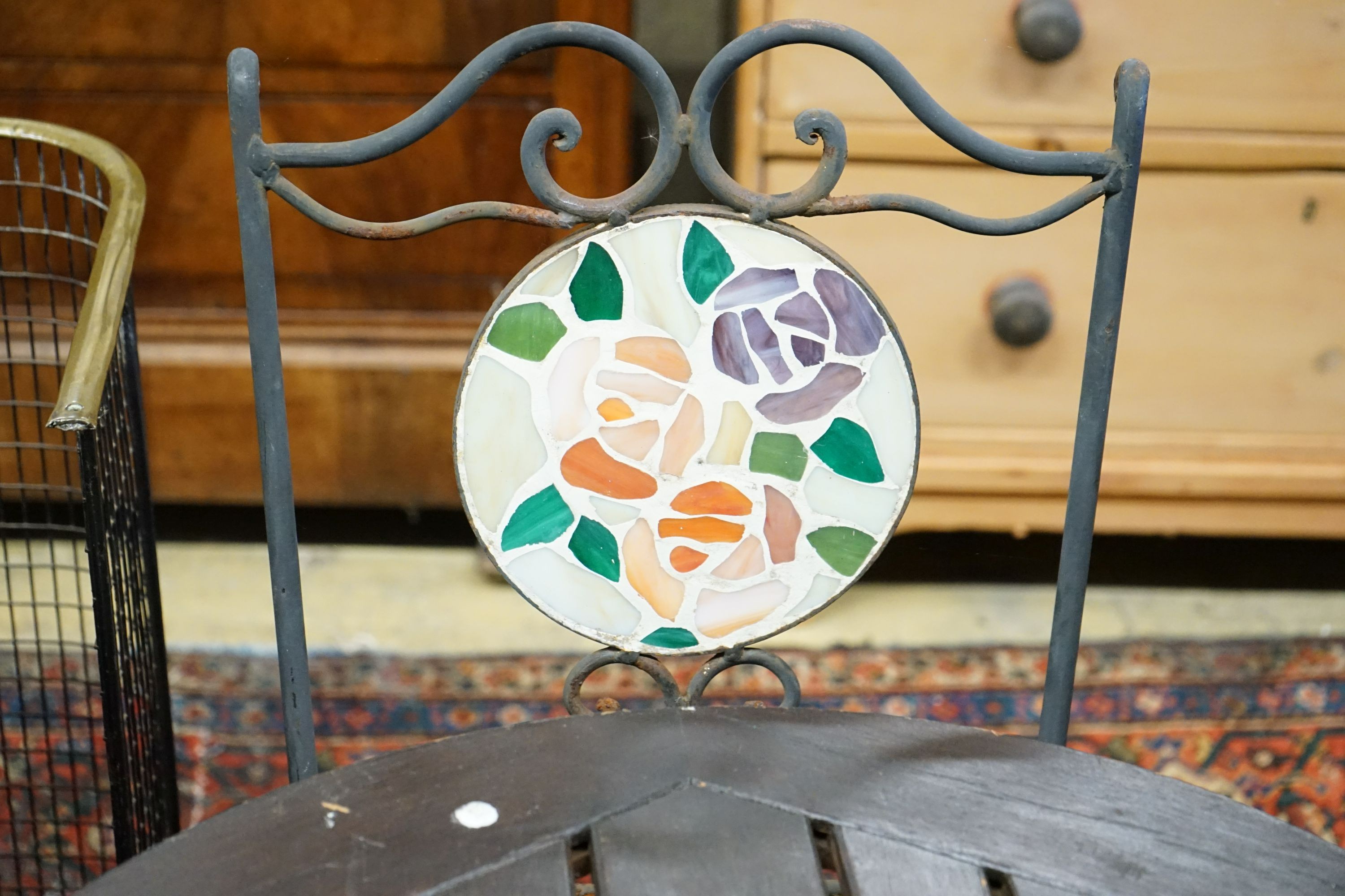 A circular cast iron based garden table, diameter 60cm together with two wrought iron mosaic folding chairs